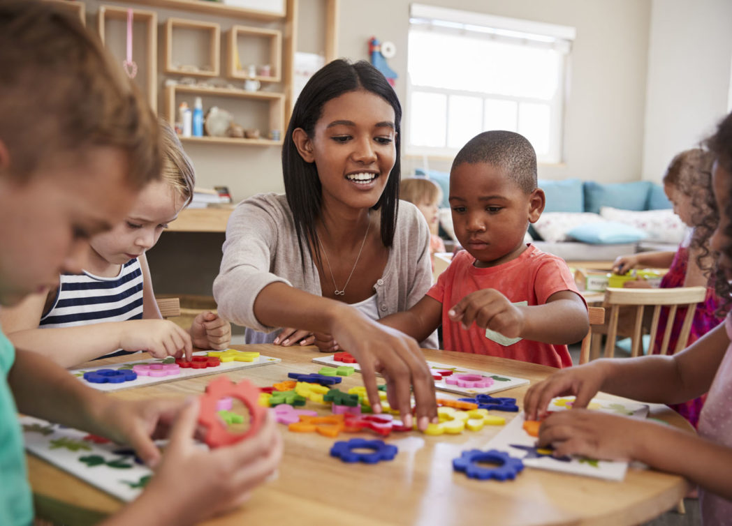 Teacher And Pupils Using Flower Shapes